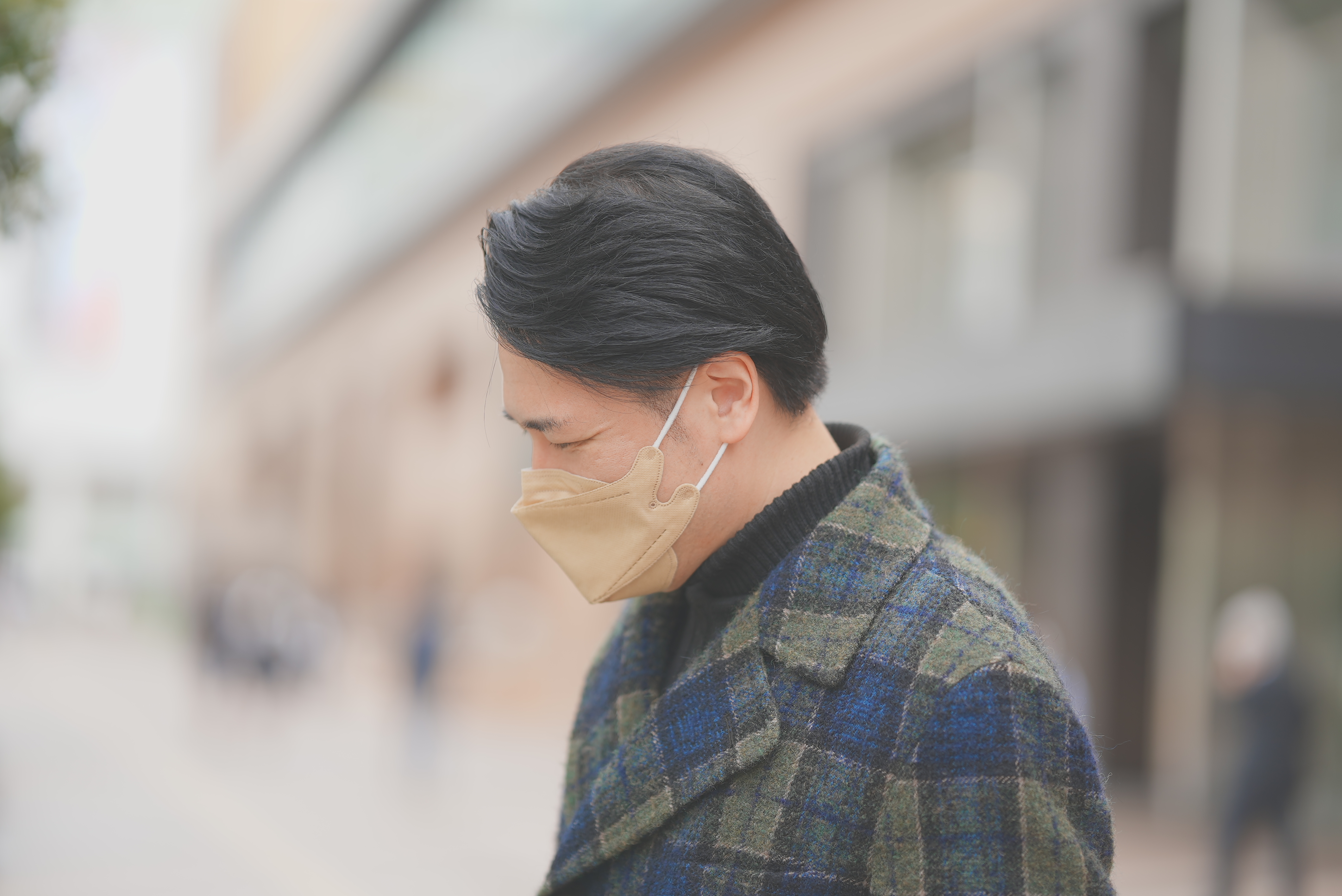 通りを歩く石井裕一（横顔）